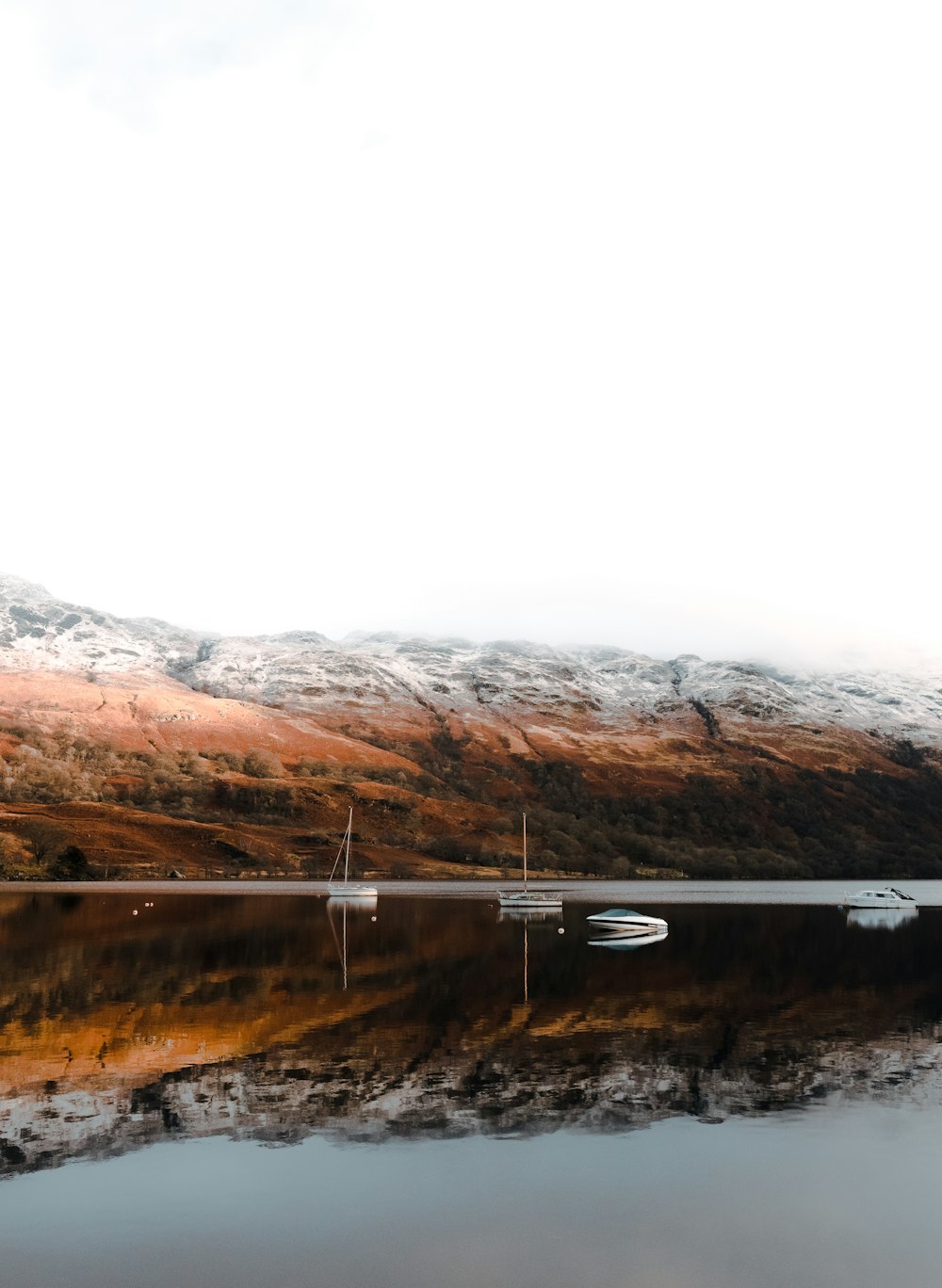 a boat on a lake with mountains in the background