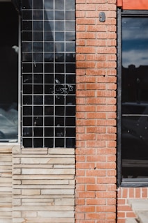 a red brick building with a black window