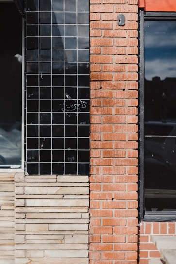 a red brick building with a black window