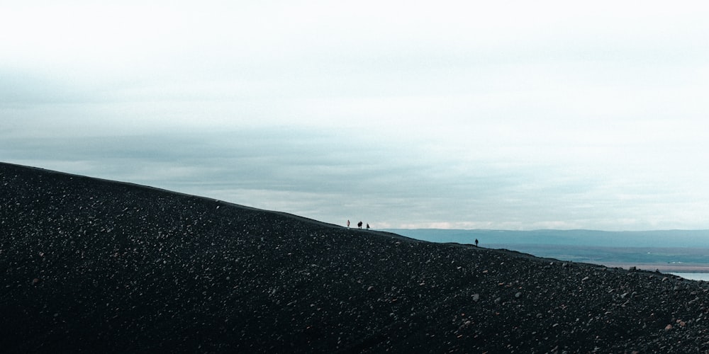 a group of people standing on top of a hill