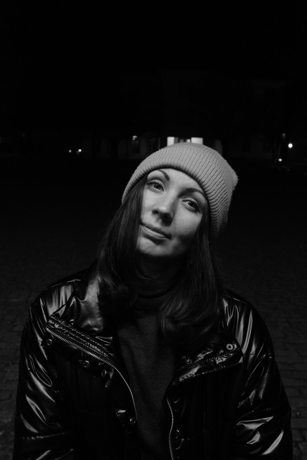 a black and white photo of a woman wearing a beanie