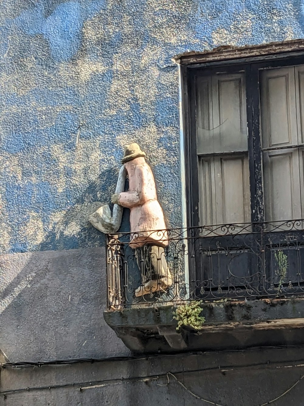 a statue of a man on a balcony of a building