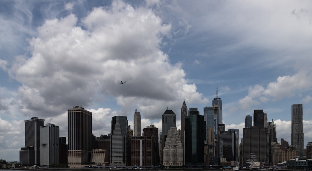 a plane flying over a large city on a cloudy day