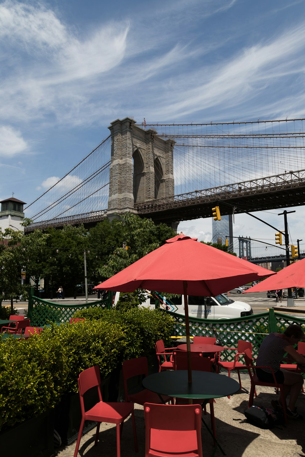 a group of tables and chairs under a bridge