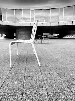 a black and white photo of a chair and table