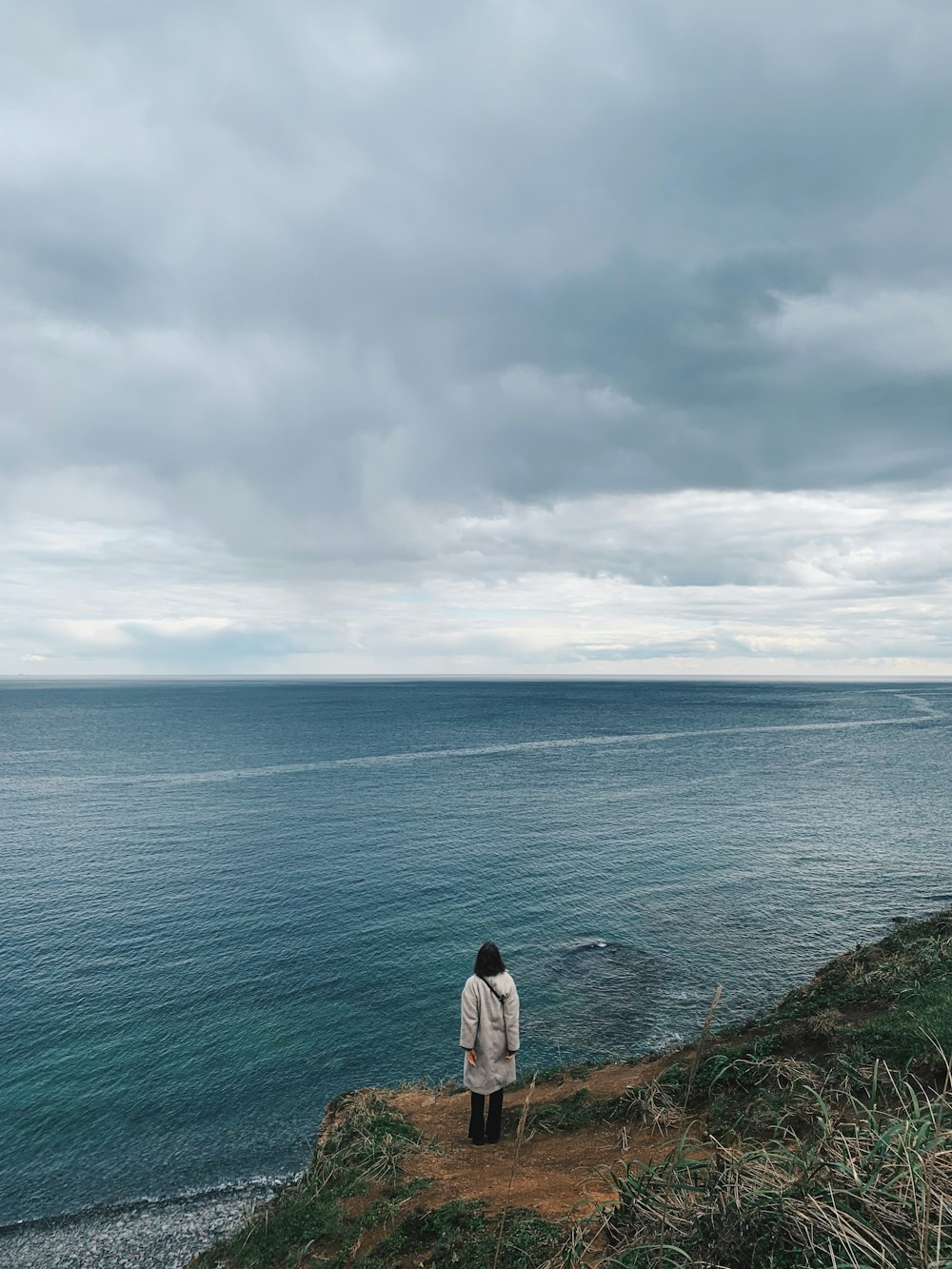 a person standing on a cliff overlooking the ocean