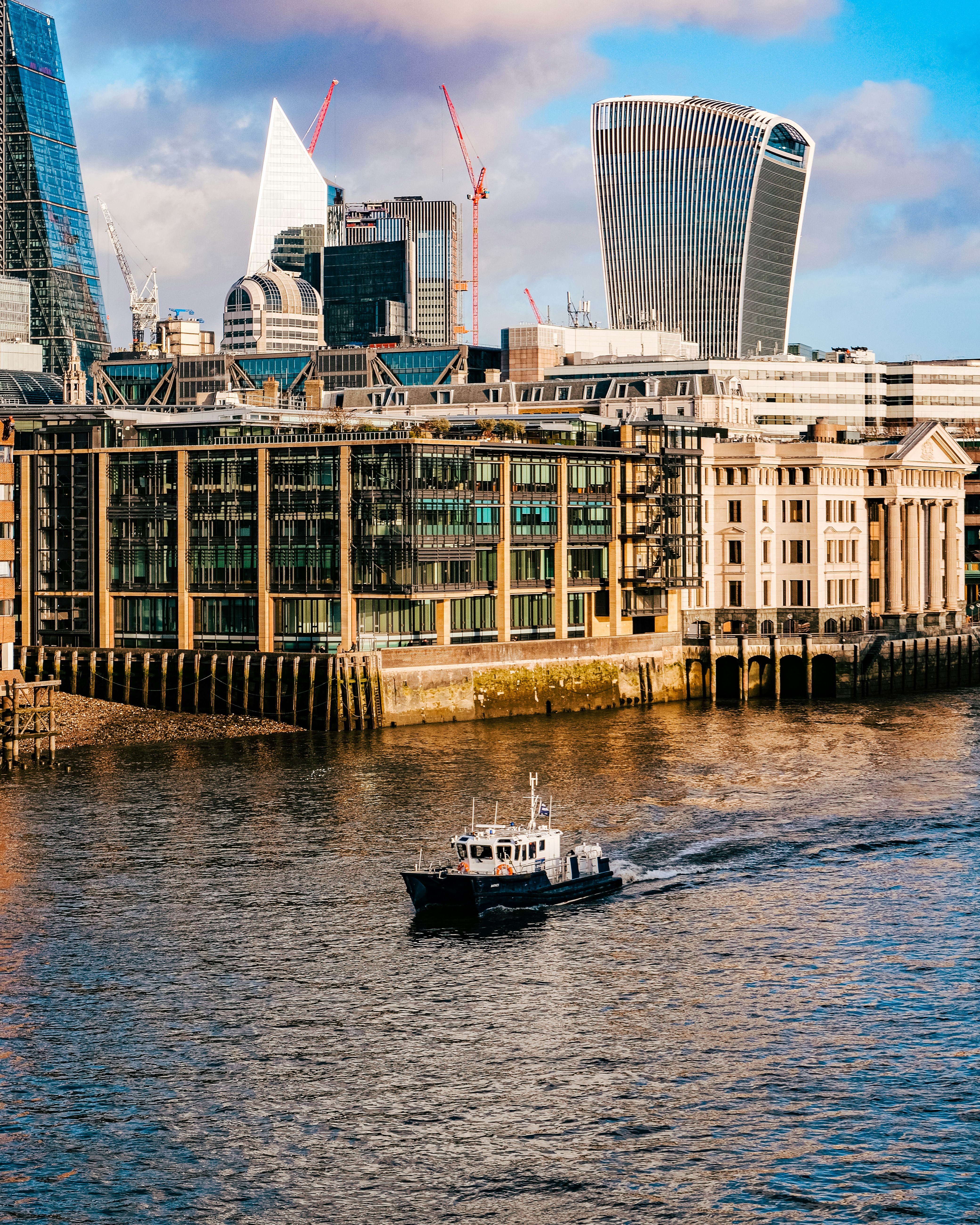 高層ビルの隣の川を下るボート