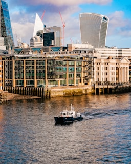 a boat traveling down a river next to tall buildings