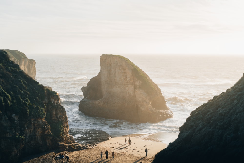 a group of people standing on top of a sandy beach