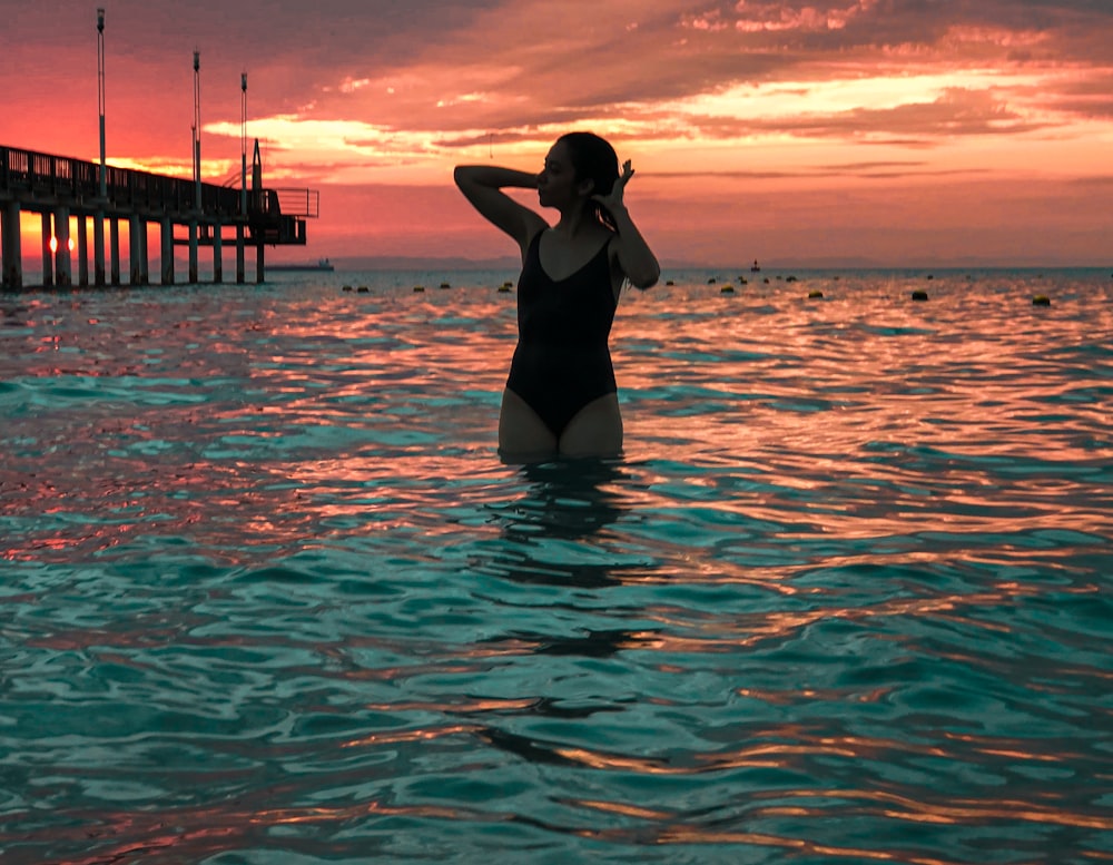 a woman in a bathing suit standing in the water