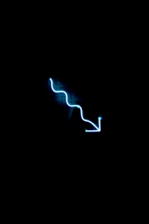 a blue neon sign on a black wall