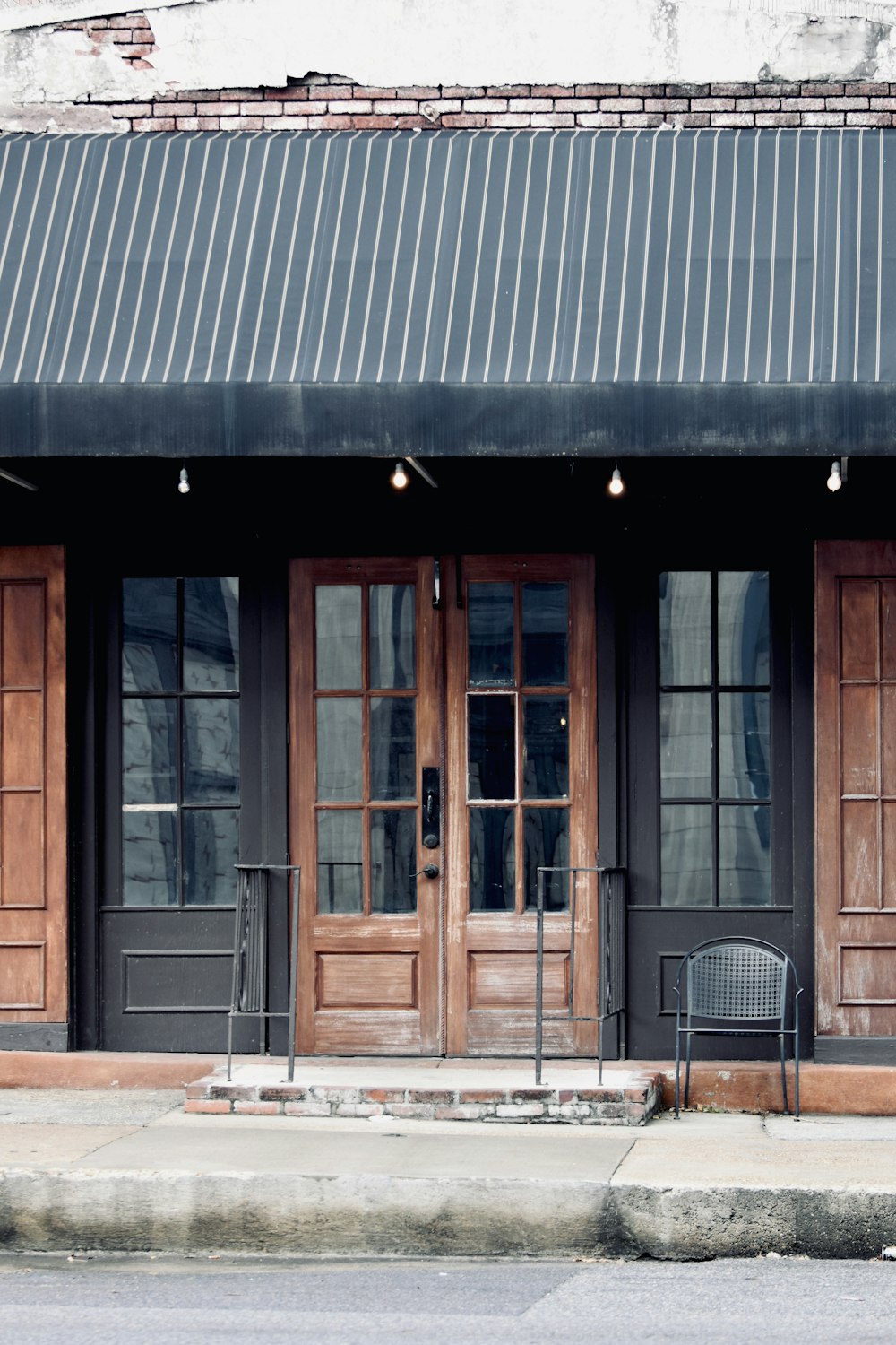 a building with two doors and a bench in front of it