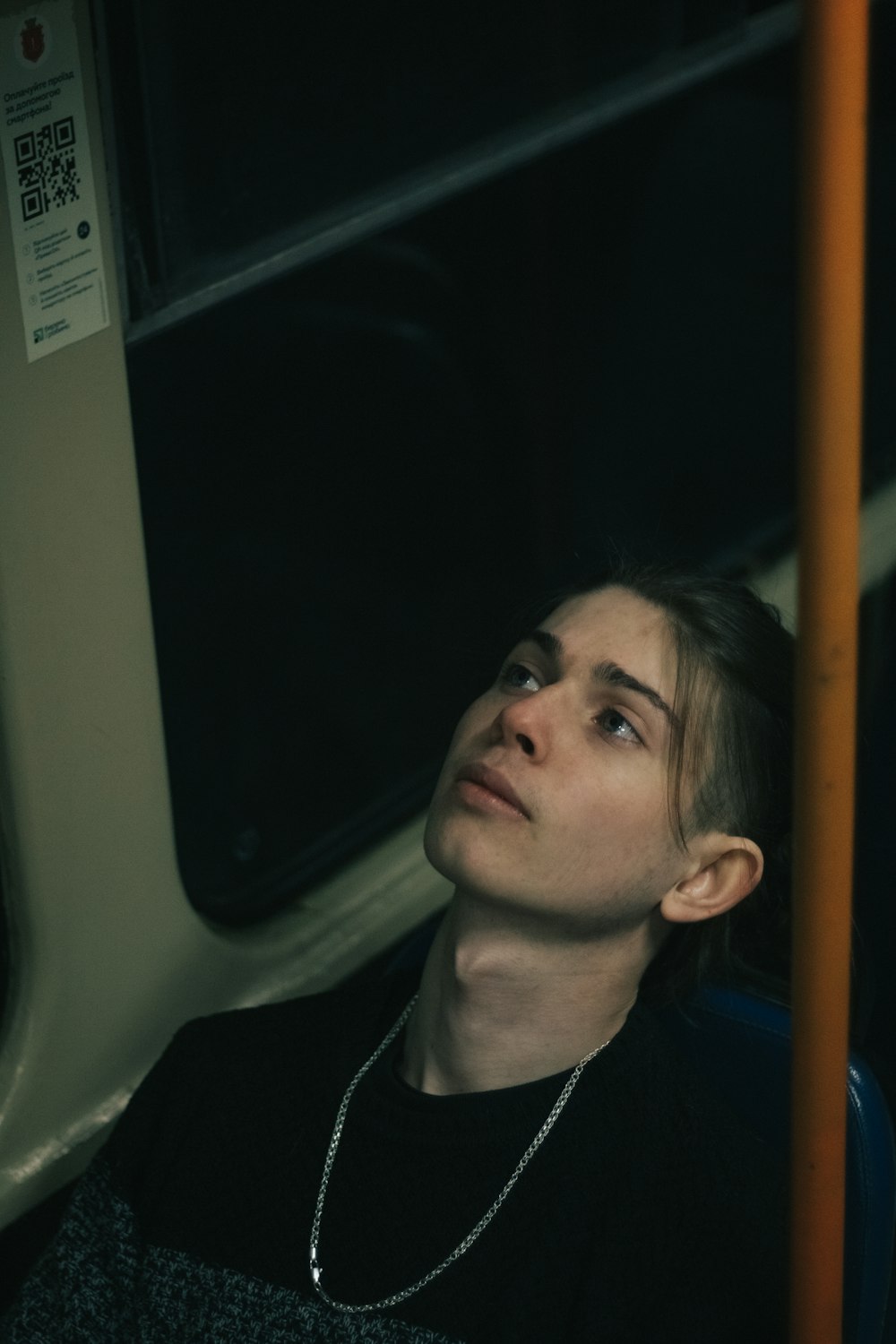 a woman sitting on a bus looking up