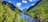 A breathtaking view of the Himalayan mountains with lush greenery and a serene river flowing through the valley.