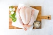 Whole fresh chicken ready for cooking on a rustic kitchen table