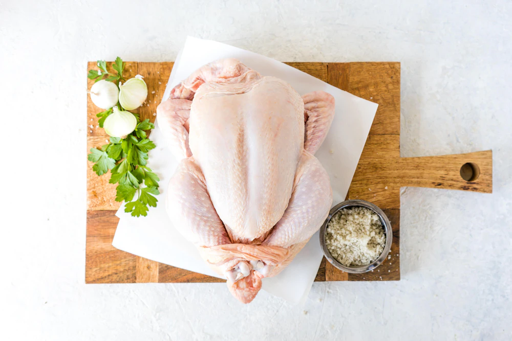 Whole dressed squab chicken on a wooden board