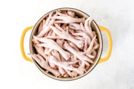 a pot filled with raw chicken on top of a table