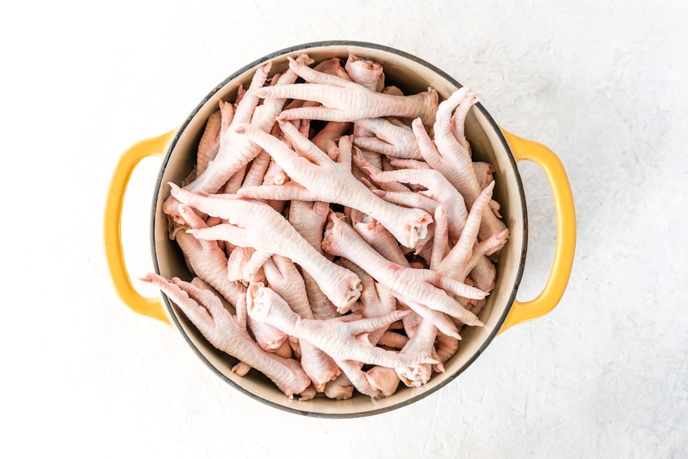 a pot filled with raw chicken on top of a table