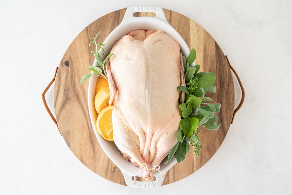 a raw chicken sitting on top of a wooden cutting board