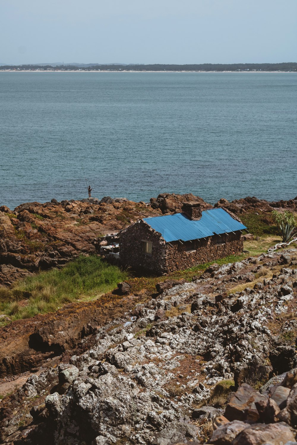 a small house sitting on top of a rocky hillside