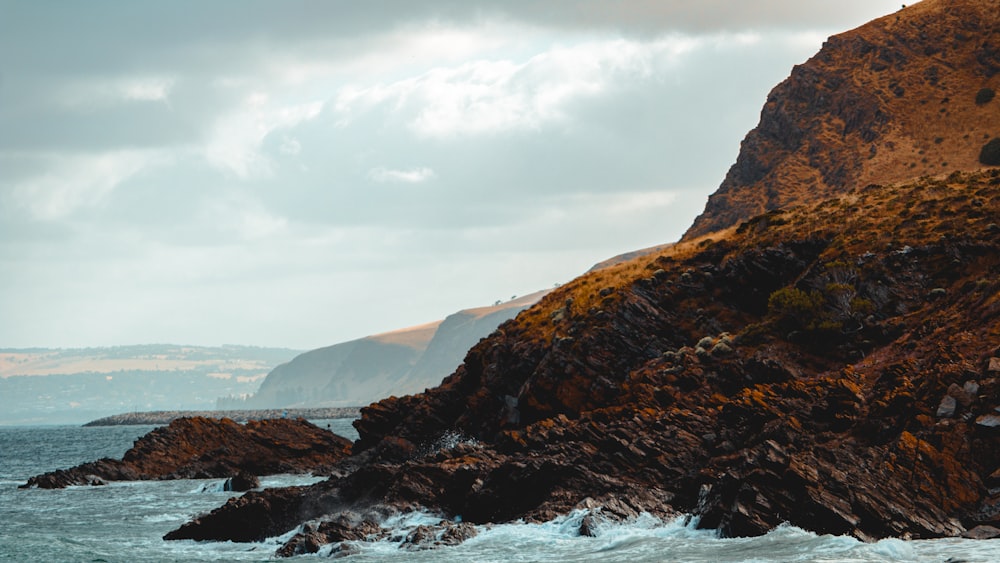 a person riding a surfboard on a rocky shore