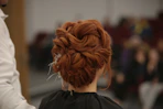 a woman with red hair is getting her hair done