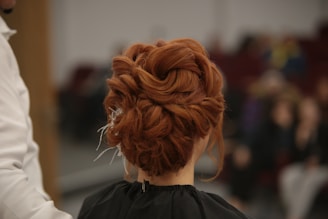 a woman with red hair is getting her hair done
