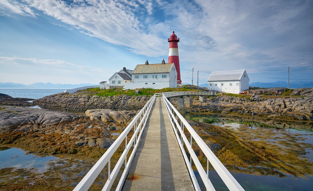 a red and white lighthouse sitting on top of a pier