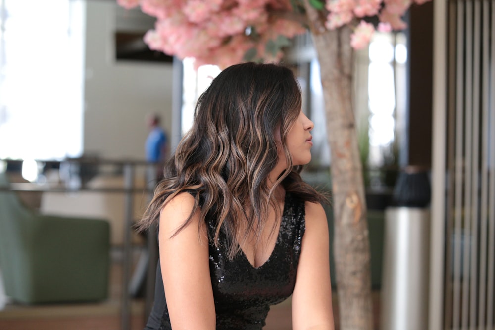 a woman in a black dress sitting on a bench