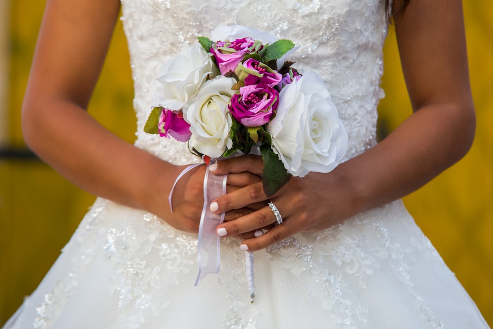 a woman in a wedding dress holding a bouquet of flowers