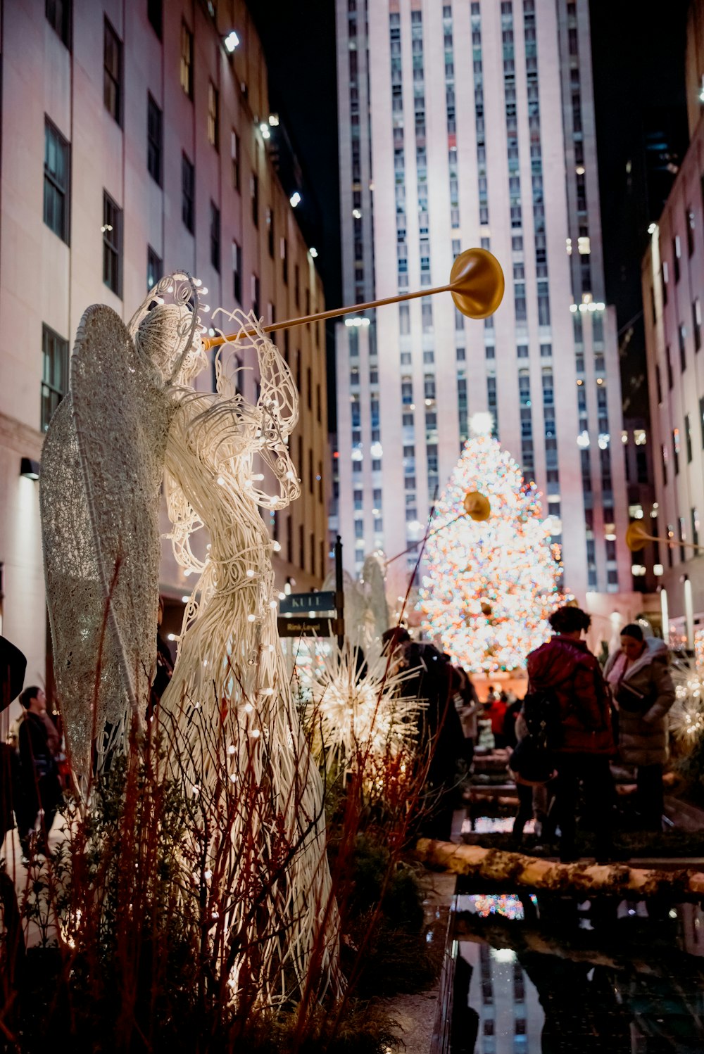 a group of people standing around a christmas tree