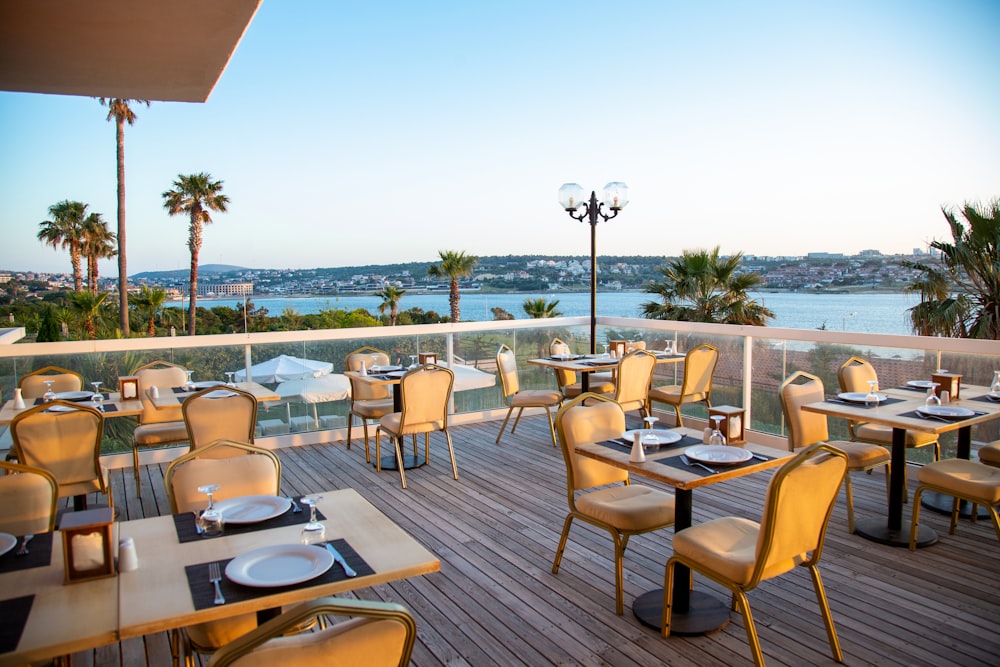 a restaurant with tables and chairs overlooking a body of water