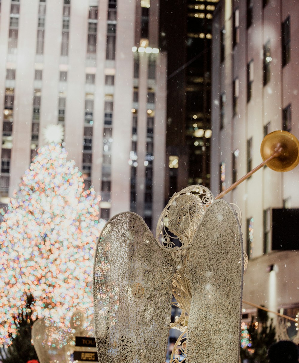 a christmas tree is in the background behind a pair of angel statues
