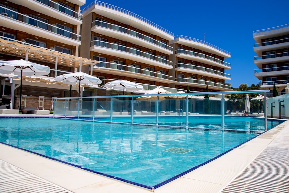 an empty swimming pool in front of a hotel