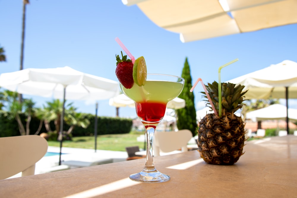 a pineapple and strawberry drink sitting on a table