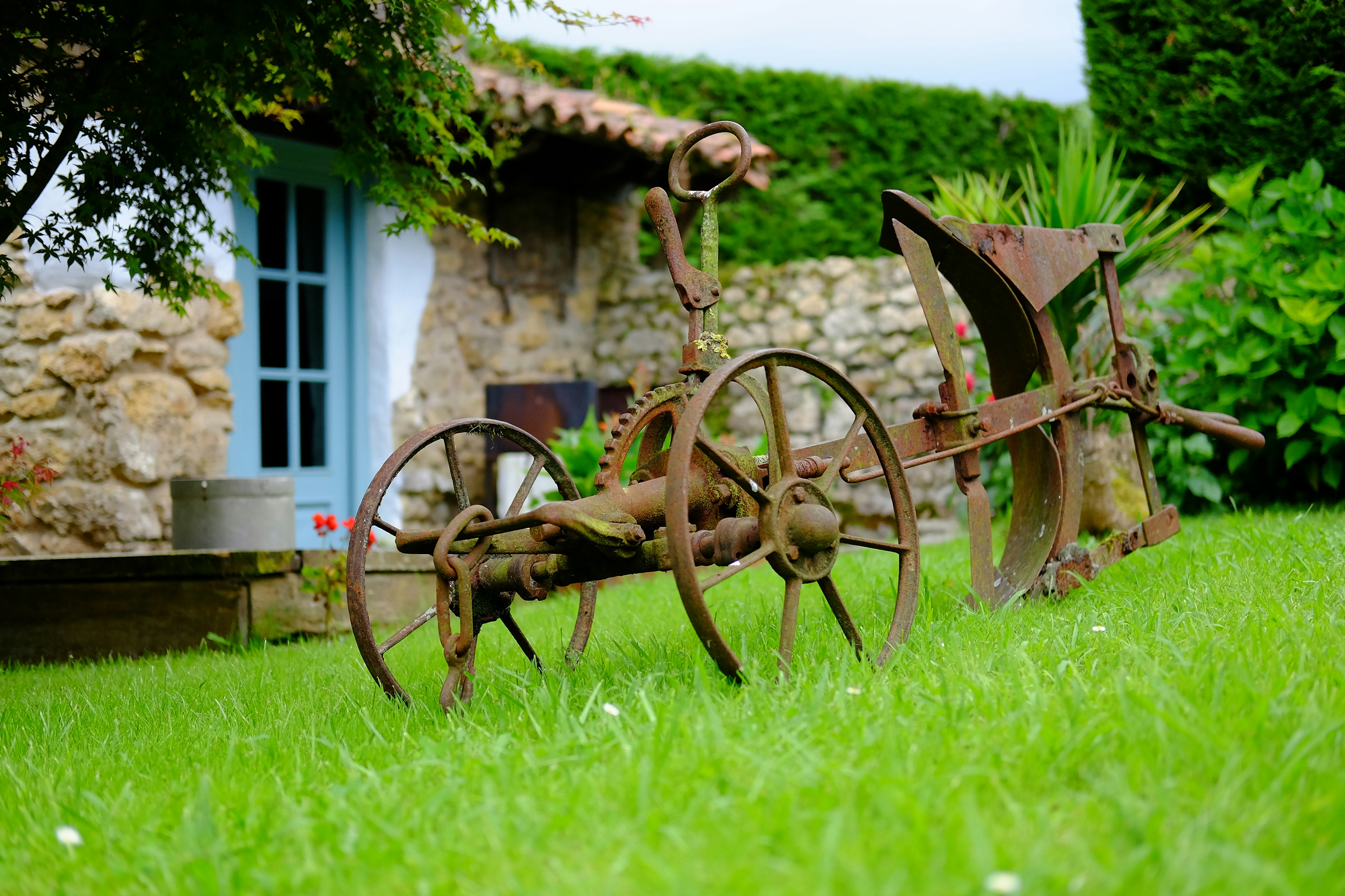 an old rusty plow sitting in the grass