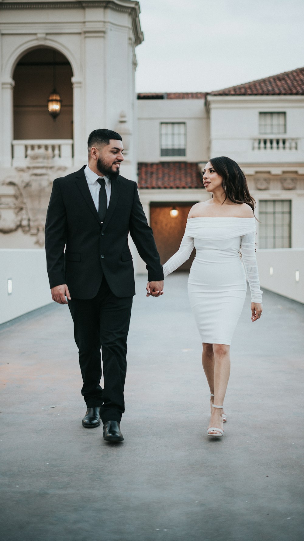 a man and a woman holding hands and walking