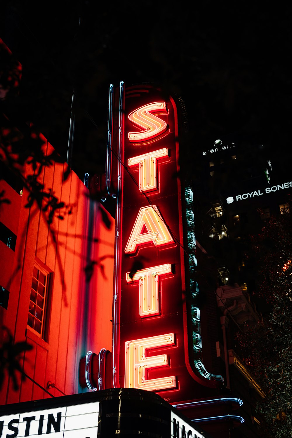 a neon sign that says state theatre on the side of a building
