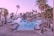 A serene tropical resort setting with tall palm trees surrounding a large, inviting swimming pool. The pool area is equipped with numerous white loungers and umbrellas, and a thatched-roof hut can be seen in the distance. The ocean is visible beyond the pool, and the sky is painted with soft hues of pink and purple, suggesting either sunrise or sunset.