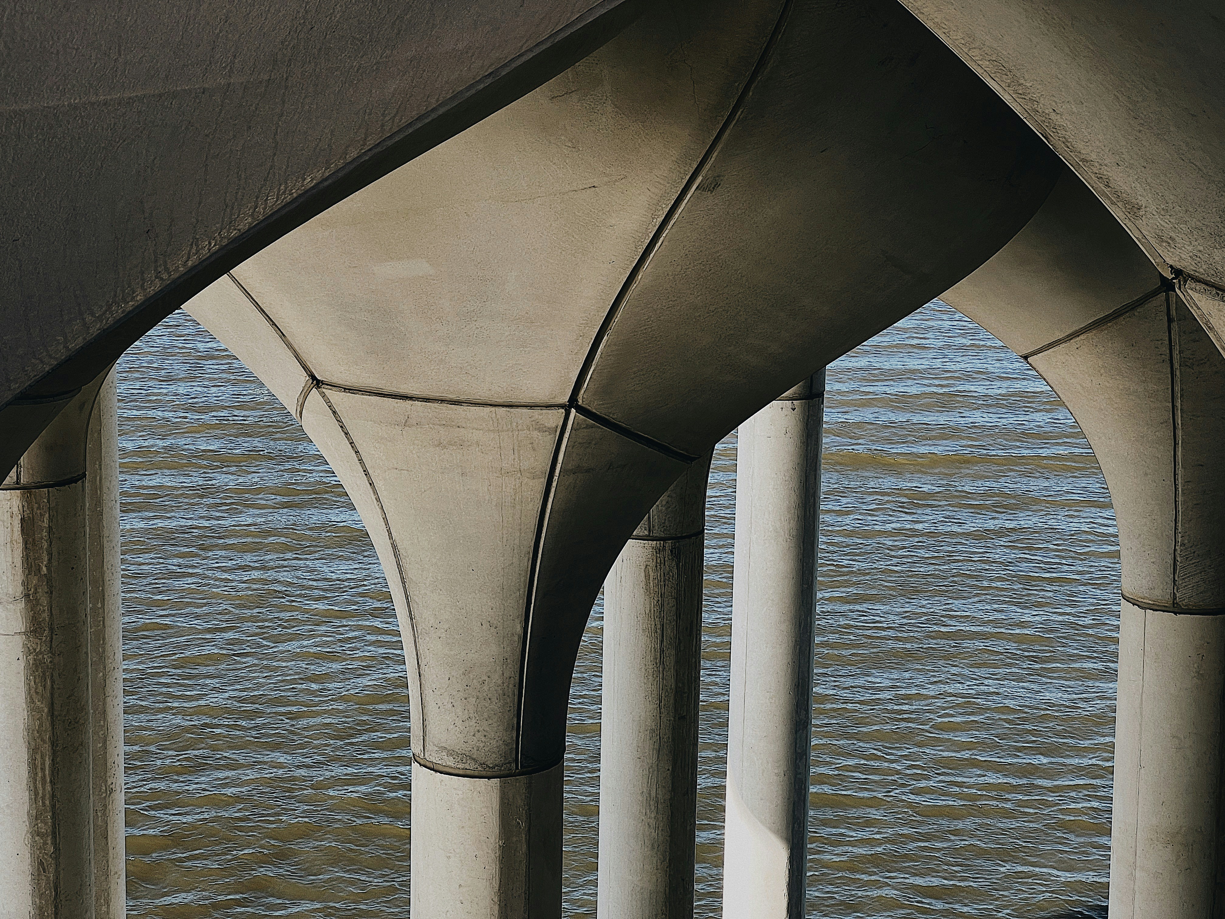 the underside of a bridge over a body of water