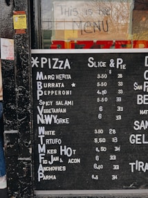 a menu for a pizza restaurant on the side of a building