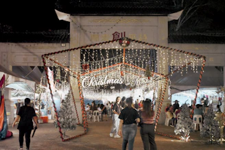A colorful Christmas market scene in Valdemoro with festive lights and cheerful visitors.