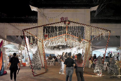 A colorful Christmas market scene in Valdemoro with festive lights and cheerful visitors.