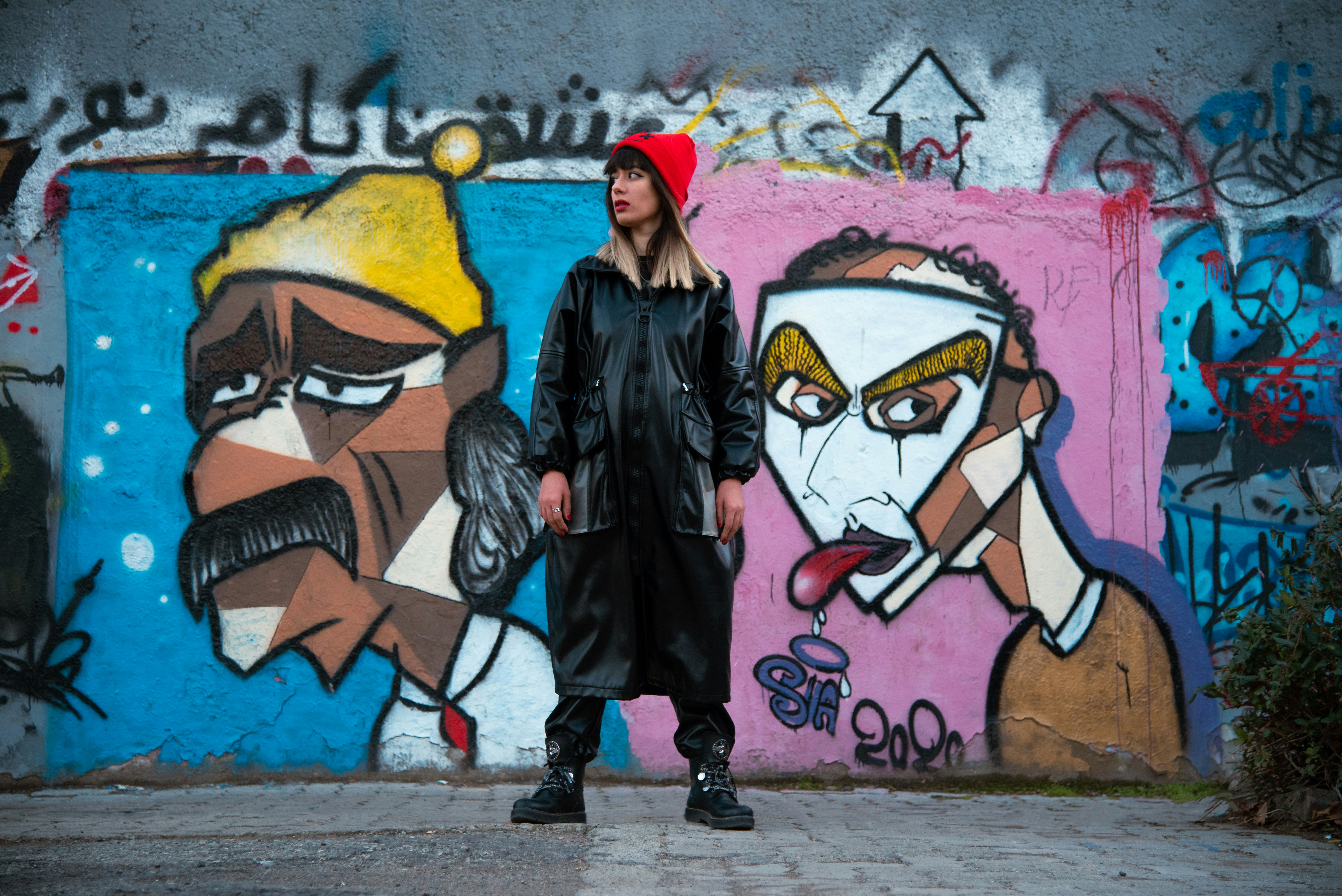 a woman standing in front of a graffiti wall