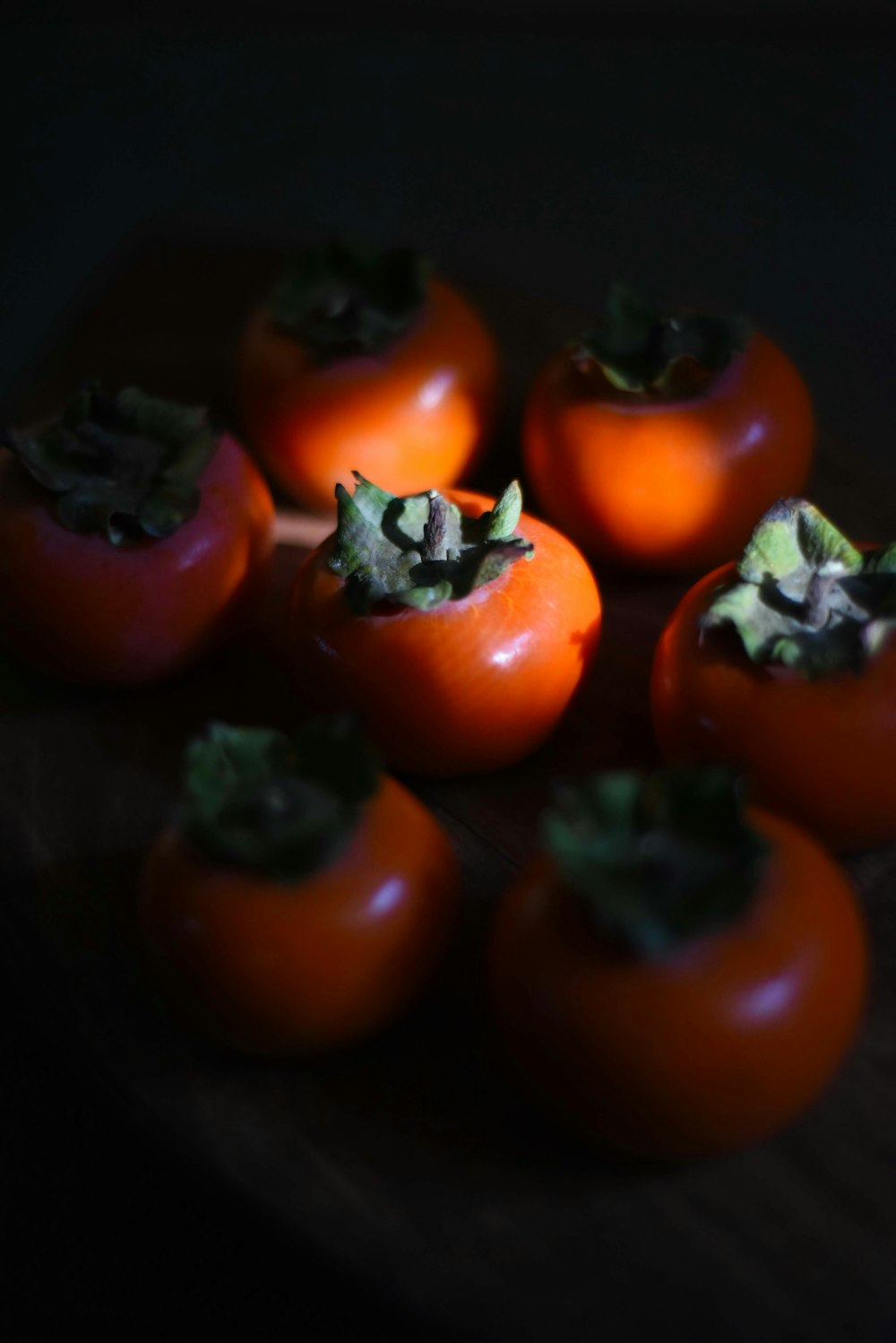 Un manojo de tomates sentado encima de una mesa de madera