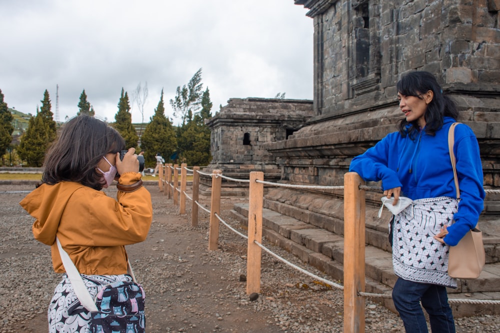 a woman standing next to a woman on a cell phone