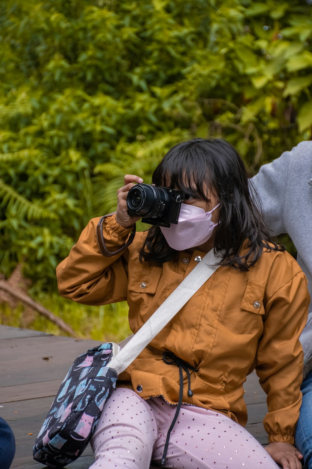 a woman wearing a face mask while sitting on a bench