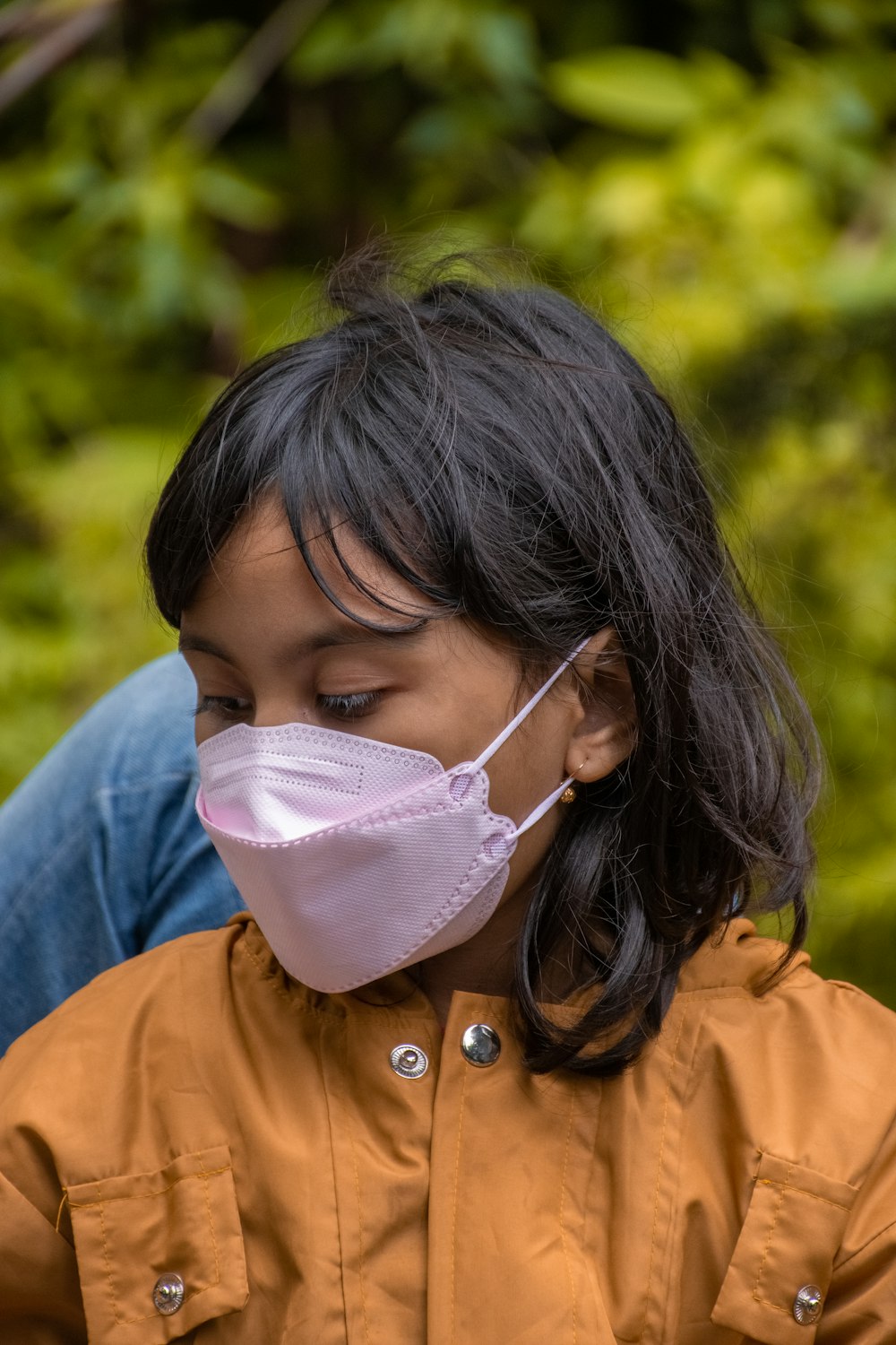 a woman wearing a face mask while looking at her cell phone