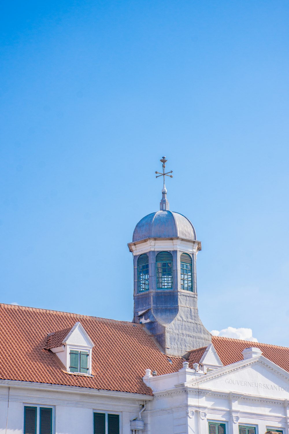 a building with a steeple and a cross on top