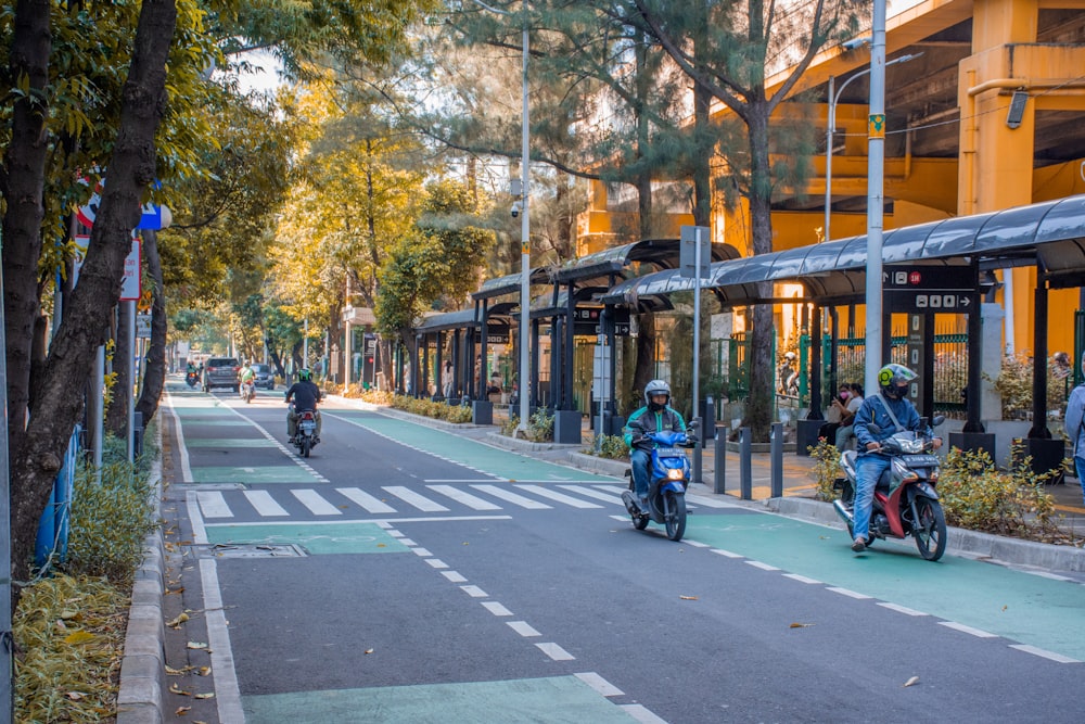 a group of people riding motorcycles down a street